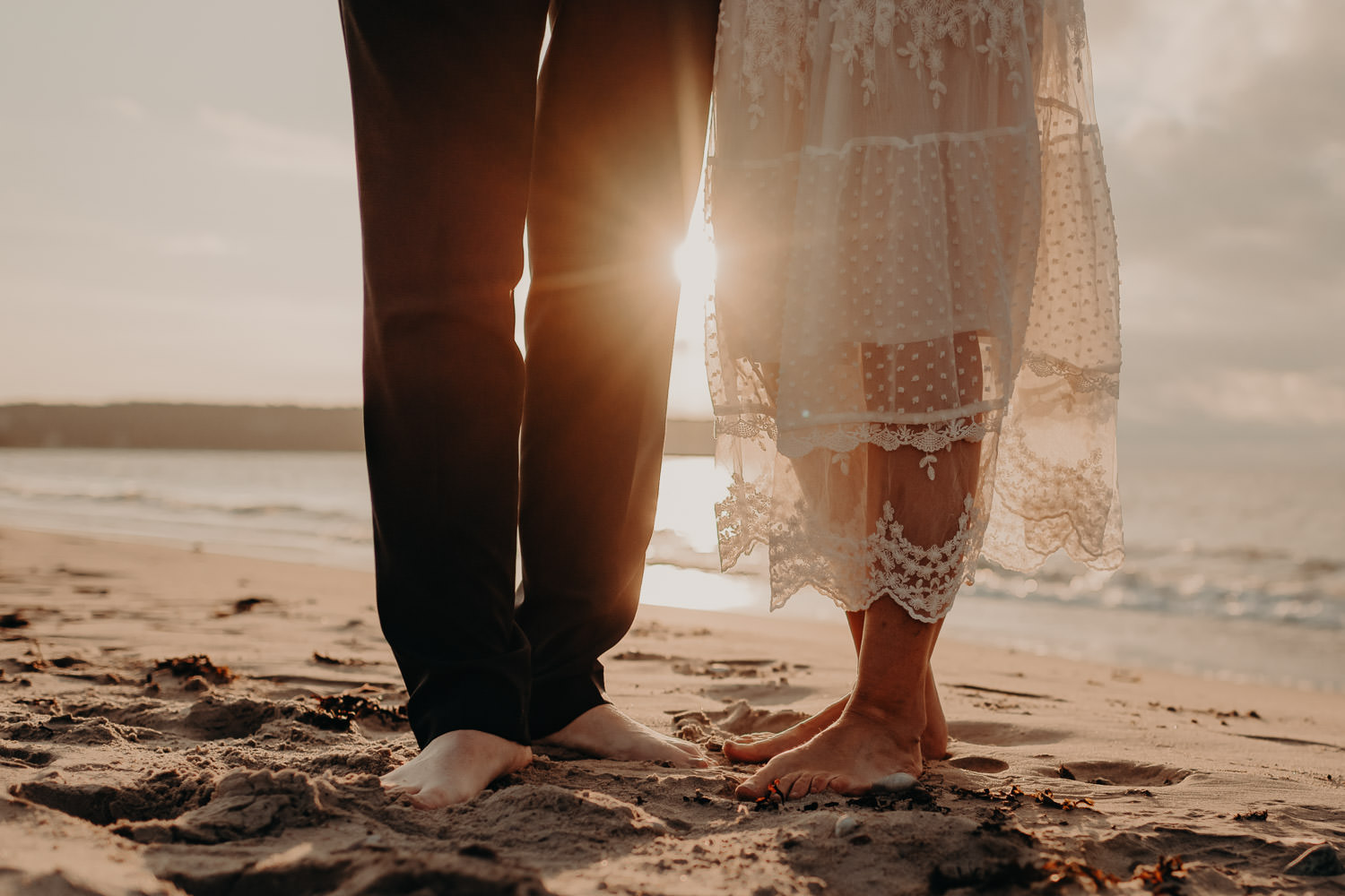 wedding couple barefoot on the beach at sunset