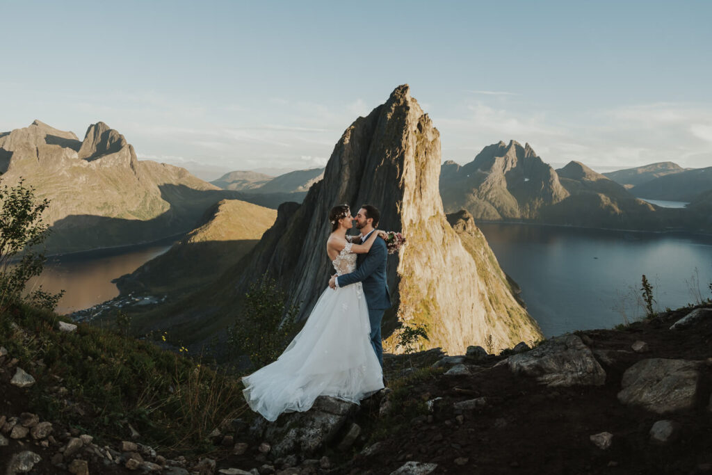 Elopement couple embracing on a mountain top in Senja Norway during sunset