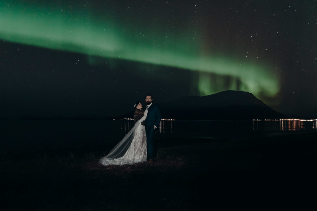 Wedding couple embracing under the northern lights