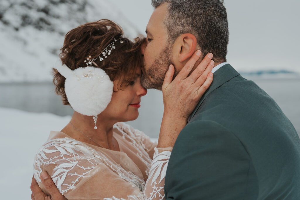 Wedding couple embracing in the cold during their winter elopement in Norway
